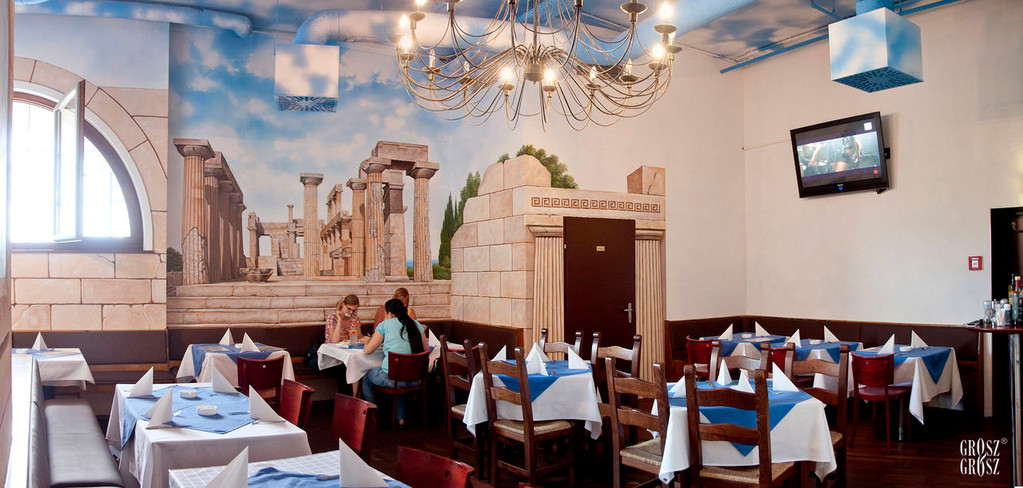Restaurantbereich mit Tempelmalerei, Kronleuchter und gedeckten Tischen